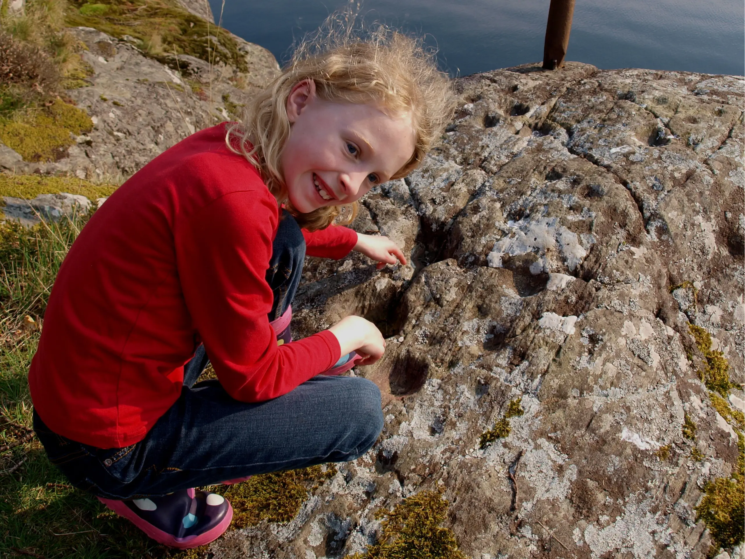 Lucy pointing out the cup and ring marks