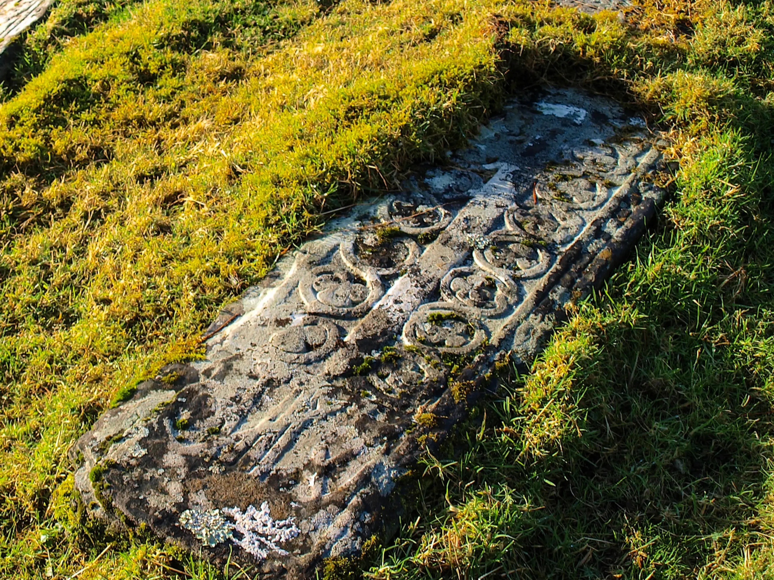 An old graveslab resting in the grass